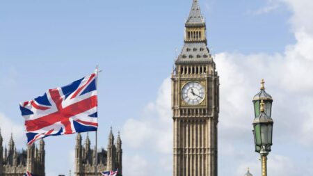 Flaga Wielkiej Brytanii na tle Palacu Westminsterskiego w Londynie
