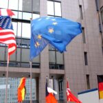 Flagi UE i USA na budynku Parlamentu Europejskiego w Brukseli